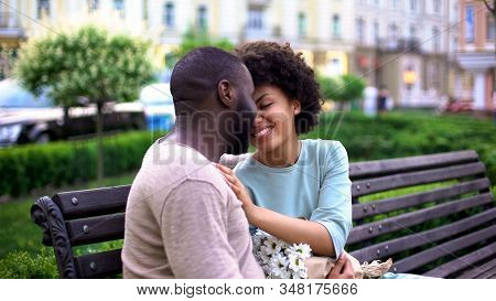 Afro-american Loving Couple Nuzzling On Bench, Enjoying Summer Day Together