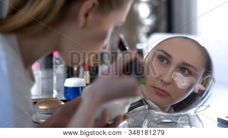 Fashionable Woman Gently And Carefully Putting Moisturizing Mask Under Eyes