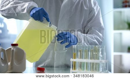 Scientist Inaccurately Pouring Biofuels From Can, Research Into New Safe Fuels