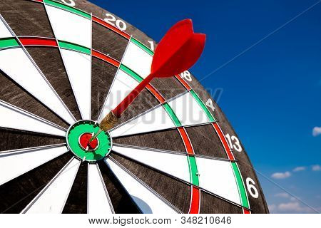 Dart Arrow Hit On Bulleyes Of Dartboard With Blue Sky, Planning New Business Target And Goals.