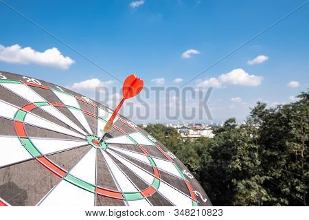 Dart Arrow Hit On Bulleyes Of Dartboard With Blue Sky, Planning New Business Target And Goals.