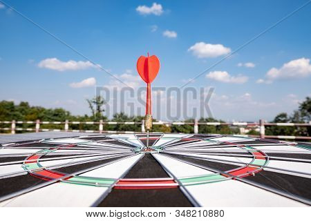 Dart Arrow Hit On Bulleyes Of Dartboard With Blue Sky, Planning New Business Target And Goals.