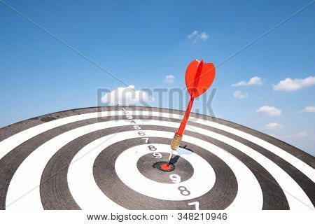 Dart Arrow Hit On Bulleyes Of Dartboard With Blue Sky, Planning New Business Target And Goals.