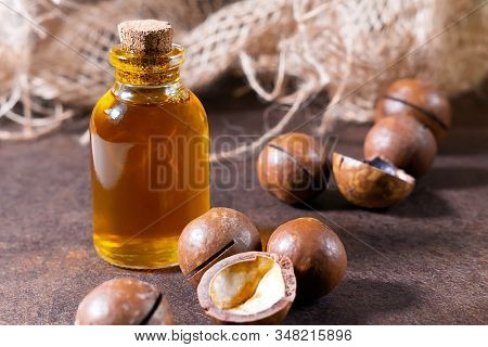 Cosmetic And Medicinal Macadamia Oil, On A Brown Background, Close-up. Oil For Women, Cosmetology, T