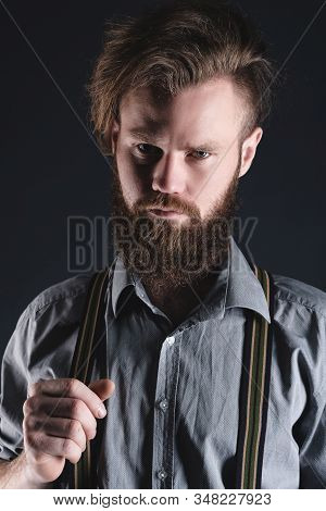 Young, Handsome Man With A Beard Posing On A Black Background In The Studio.