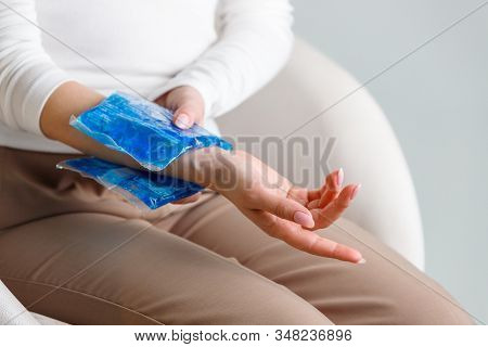 Close Up Of Woman Applying Cold Compress To A Her Painful Wrist Caused By Prolonged Work On The Comp