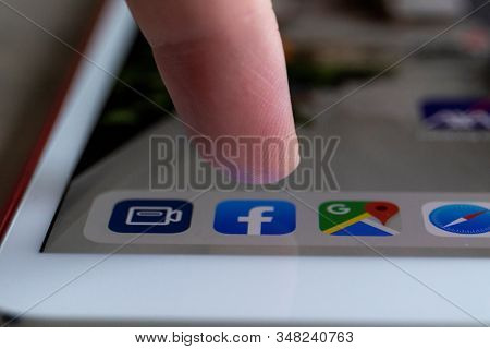 Brecht, Belgium - November 14 2019: A Portrait Of A Finger Of A User Hovering Above The Facebook App