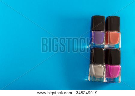 Four Gel Polishes On Blue Background