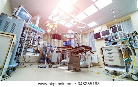 Clinic Interior With Operating Surgery Table, Lamps And Ultra Modern Devices, Technology, Hi-tech In