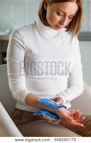 Close Up Of Woman Applying Cold Compress To A Her Painful Wrist Caused By Prolonged Work On The Comp