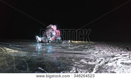 Young Loving Couple Skating At Ice Rink At Night. Man And Woman Kiss Hug Have Fun Learn To Skate. Ma