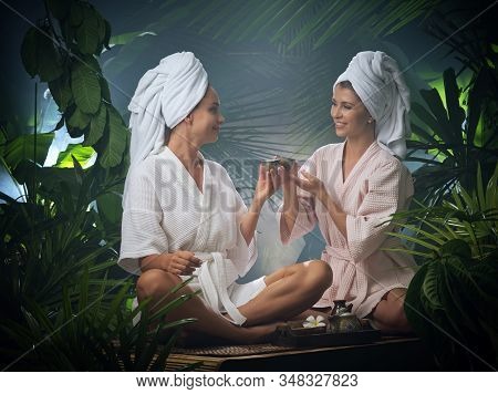 Portrait Of Young Beautiful Women Drinking Tea  In Spa Environment.