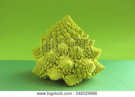 Head Of A Decorative Romanesco Cauliflower On A Green Background With Copy Space