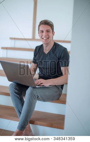 cheerful young man talking by video link using laptop