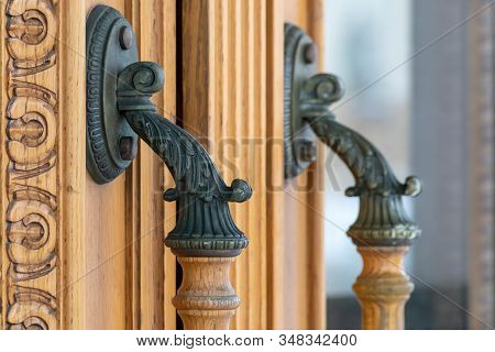 Old Bronse Handles On A Wooden Door With Carved Ornament