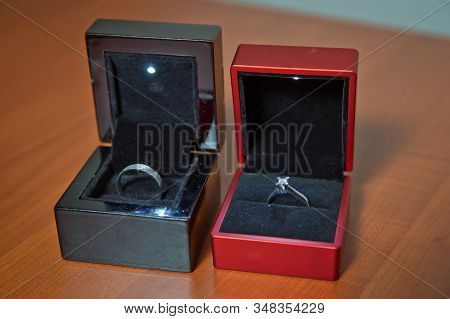 Couple Wedding Rings In A Gift Box Isolated On Wooden Background . Woman Abd Man Engagement Rings . 