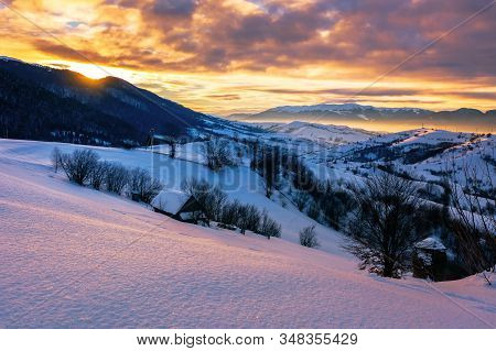 Mountainous Countryside In Winter At Sunrise. Snow Covered Hills And Fields Of Carpathian Rural Area