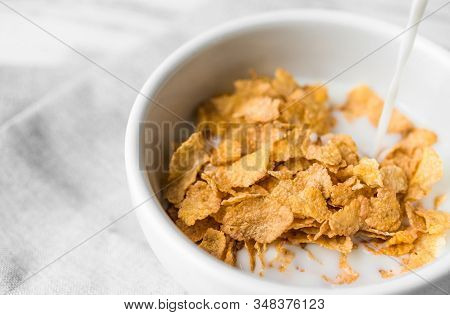 Bowl Of Breakfast Cereals With A Swig Of Milk Pouring Into It.