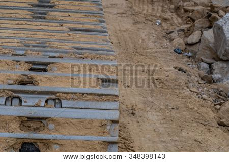 Closeup Of Backhoe Track Caked With Dry Mud At New Construction Site.