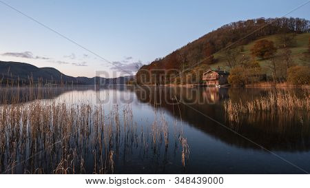 Stunning Sunrise Autumn Fall Landscape Image Of Ullswater In Lake District With Golden Sunlight