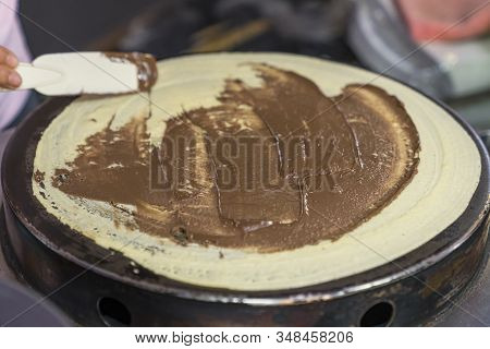 Thai Pancakes Preparation: Smearing And Spreading Chocolate Paste On Pancakes Fried On A Pancake Mak