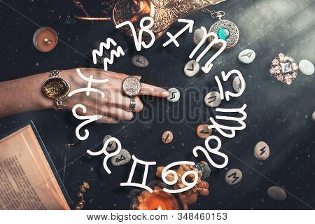 Astrology. The Witchs Female Hands Point To The Runestone. On A Black Background Lie Fortune-telling