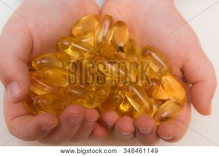 Vitaminen Omega 3 Oil In Capsules In Hand On Beige Background.