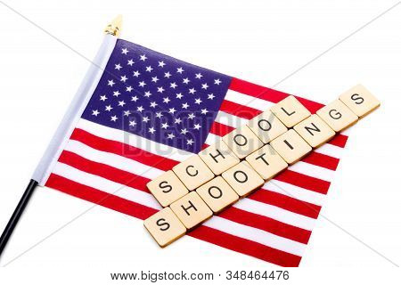 The Flag Of The United States Isolated On A White Background With A Sign Reading School Shootings