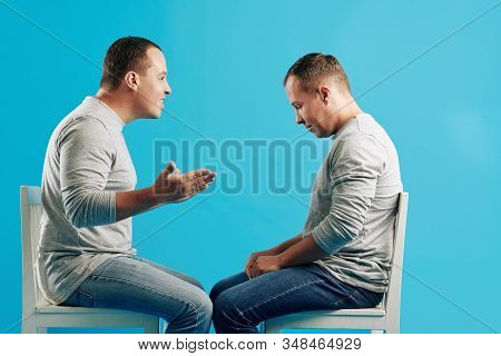 Horizontal Side View Portrait Shot Of Young Adult Man Cheering Up His Twin Brother, Brught Blue Back