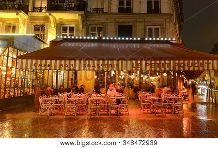 Paris, France- January 27 , 2020 :the Traditional French Cafe Petit Poucet At Rainy Evening . It Loc