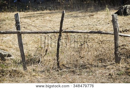 Close-up Old Rought Fence With Barbed Wire