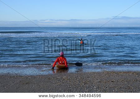 Unidentified People In Kayaks Going In To Water On North Sea Sandy Beach During Low Tide Near Castri