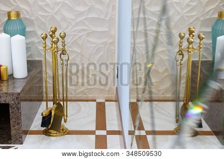 Separate parts of the interior of the living room. Fireplace and poker with reflection in the mirror.