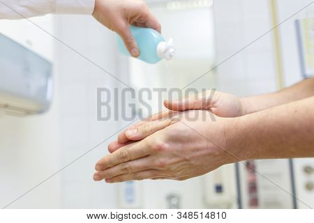 Nurse Disinfects A Patients Hand At A Sink