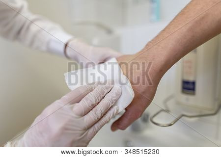 Nurse Disinfects A Patients Hand At A Sink