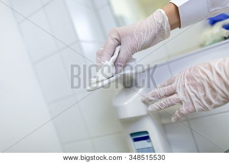 A Nurse Disinfects An Item In A Hospital Room