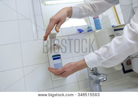 A Nurse Disinfects Her Hands In A Hospital Room