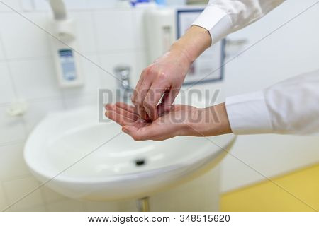 A Nurse Disinfects Her Hands In A Hospital Room