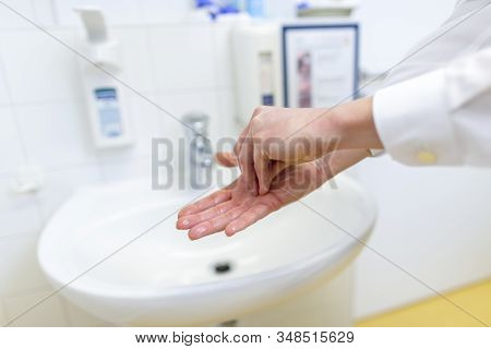 A Nurse Disinfects Her Hands In A Hospital Room