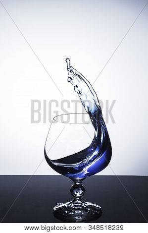Blue Liquid Splashing Out Of Wine Glass