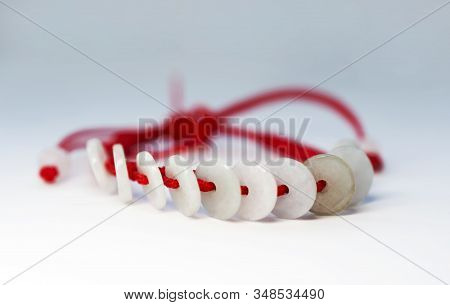 Happy Ethnic Red Thread On A Hand With Jade Coins On A White Background