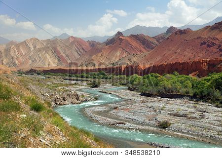 Landscape Around Pamir Highway M41 International Road In Kyrgyzstan, River And Red Colored Tianshan 