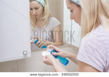 Woman Using Micellar Gel For Cleansing Her Face With A Cotton Pad, Removing Dirt And Make-up From Fa