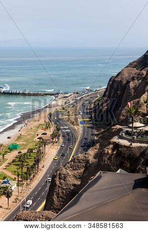 Miraflores, Lima, Peru - May 10, 2016: The Shore Of The Pacific Ocean With A Busy Highway Under Stee