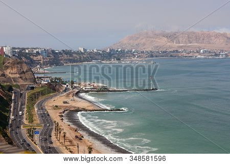 Miraflores, Lima, Peru - May 10, 2016: The Shore Of The Pacific Ocean With A Busy Highway Under Stee
