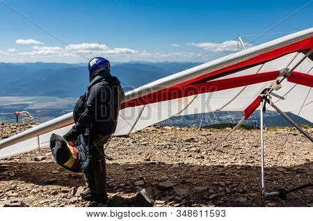 Professional Pilot Standing Near With His Hang Gliders And Getting Ready To Fly. Extremal And Risky 
