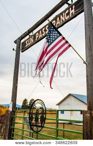 Fort Klamath, Oregon, Usa - October 23, 2018: A Tattered U.s. Flag And Wooden Archway At The Entranc