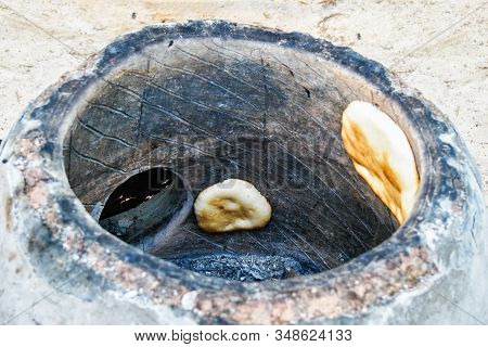 Bread In The Tandoor.traditional Way Of Baking Bread In The Tandoor. Hot Crispy Bread Cake From An E