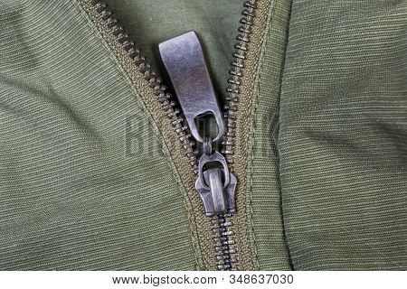 Fragment Of Partially Fastened Metal Zipper Fastener With Metal Puller On The Outerwear Olive Color 