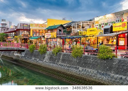 CHATAN, OKINAWA, JAPAN - MARCH 22, 2017: Shoppers enjoy the kitch storefronts of Mihama American Village at twilight.